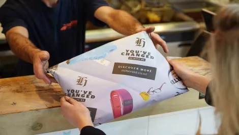 Specially printed fish and chip wrappers announce the nzherald